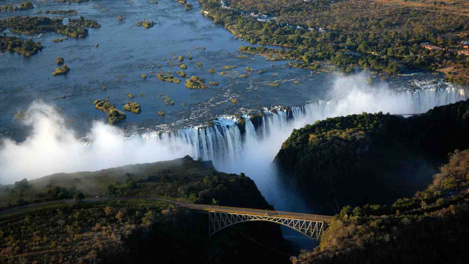 Victoria Falls experience featuring iconic waterfalls, Zambezi River landscapes, rainforest scenery, and adventure activities in Zimbabwe and Zambia